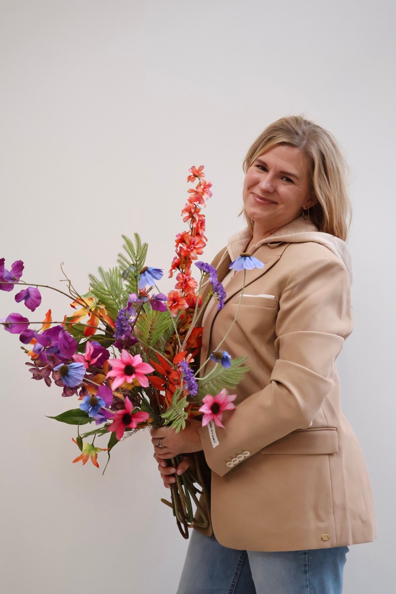 Sarah Elbertsen met een groot, kleurrijk zijden boeket