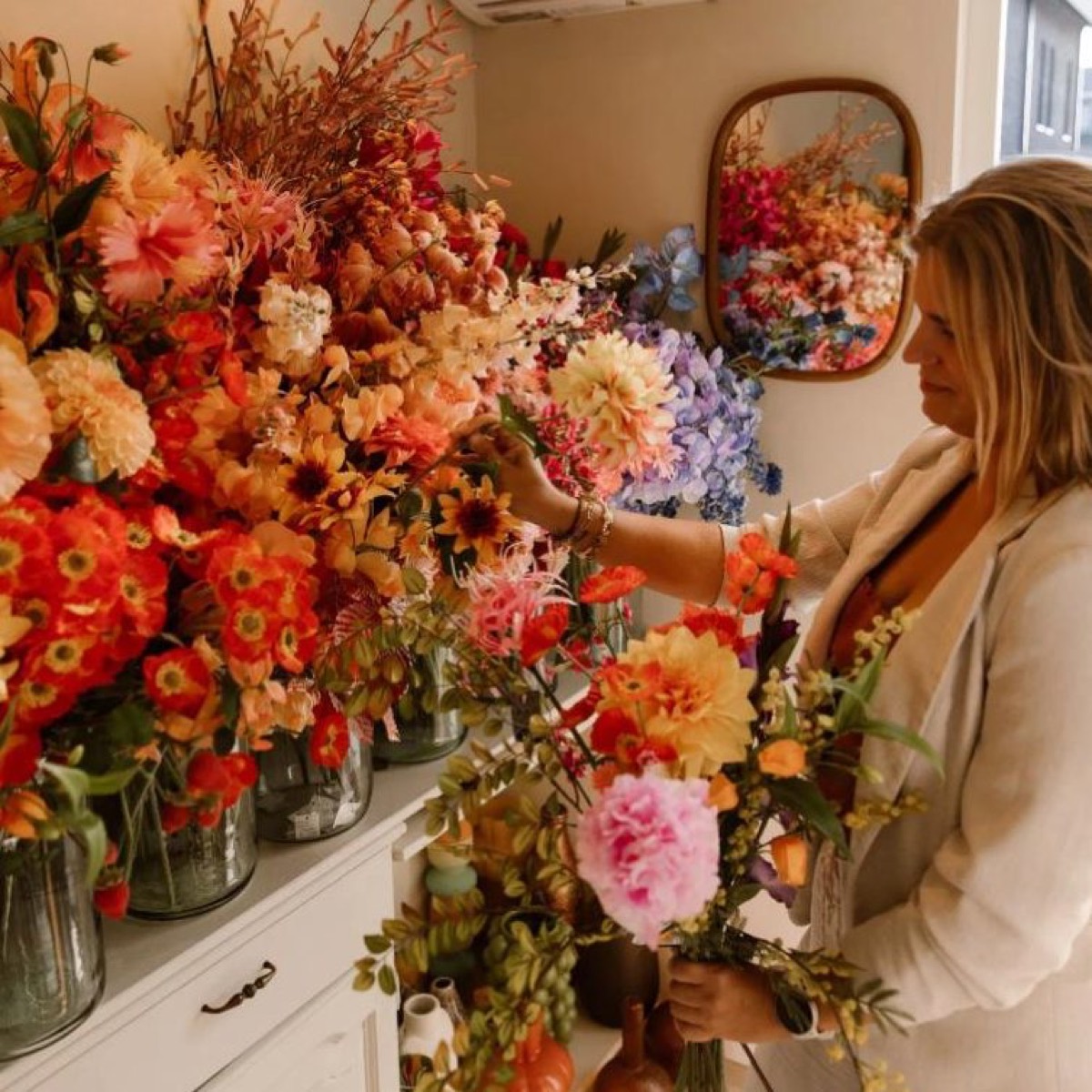 De kleurrijke bloemenwand in de studio van StudioSilkFlowers
